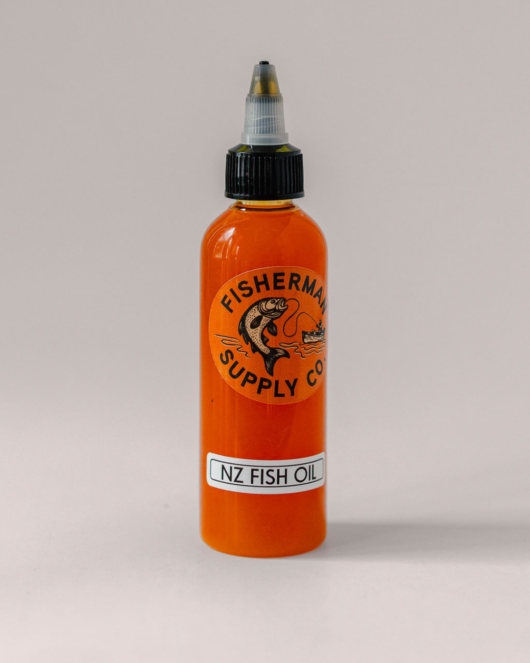 Orange bottle of NZ Fish Oil with a black cap on a light gray background